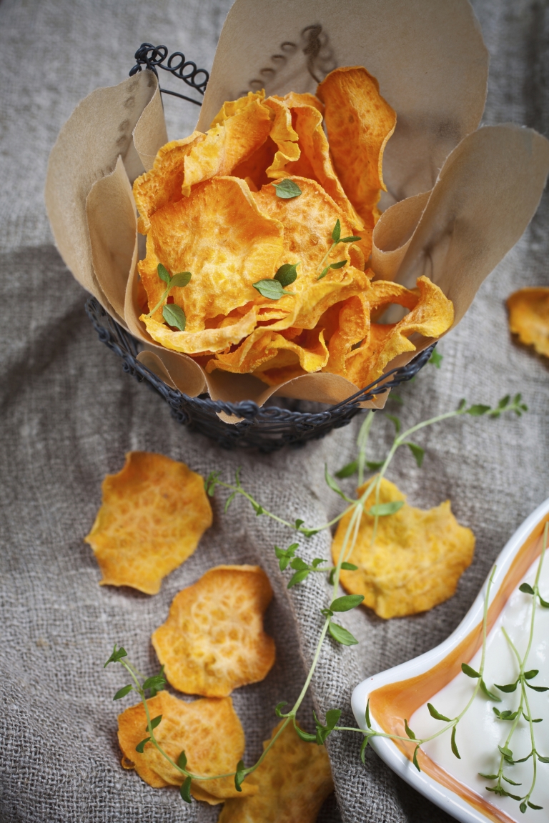 Homemade sweet potato chips with fresh thyme